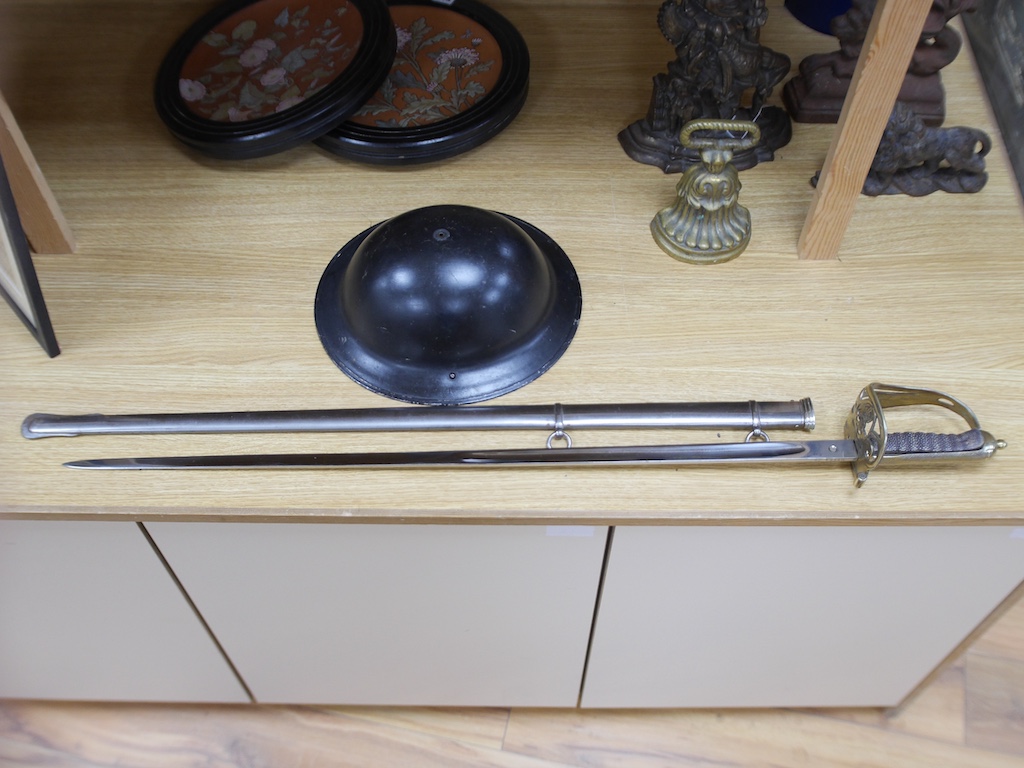 An officer's sword and WWII helmet. Condition - fair